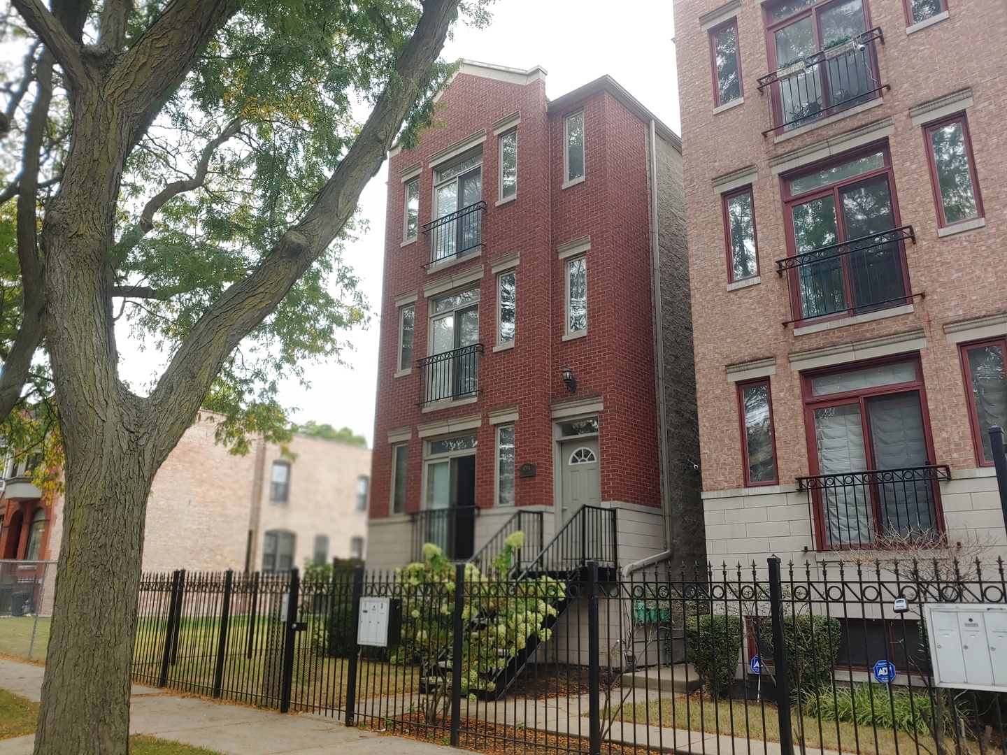 a view of a brick building next to a large tree