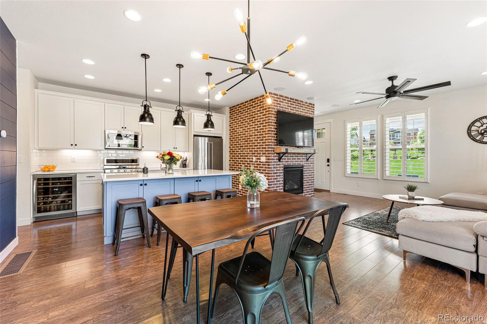 a kitchen with granite countertop a table chairs stainless steel appliances and wooden floor