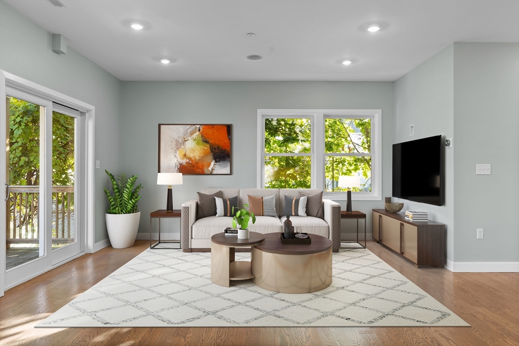 a living room with furniture a flat screen tv and a large window