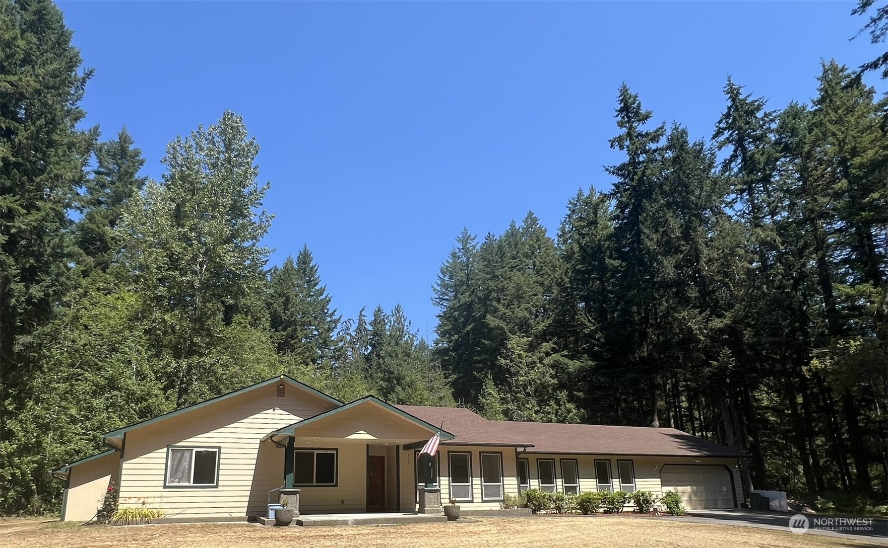 a front view of a residential houses with yard and trees