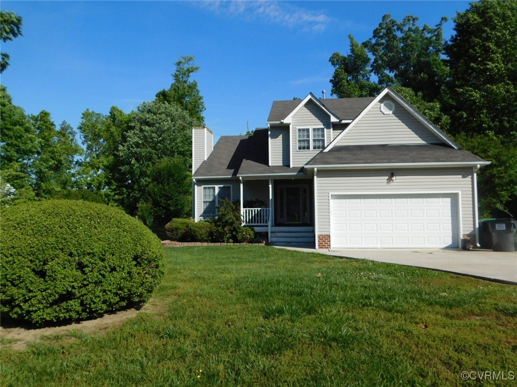 View of front of home featuring a porch, a garage,