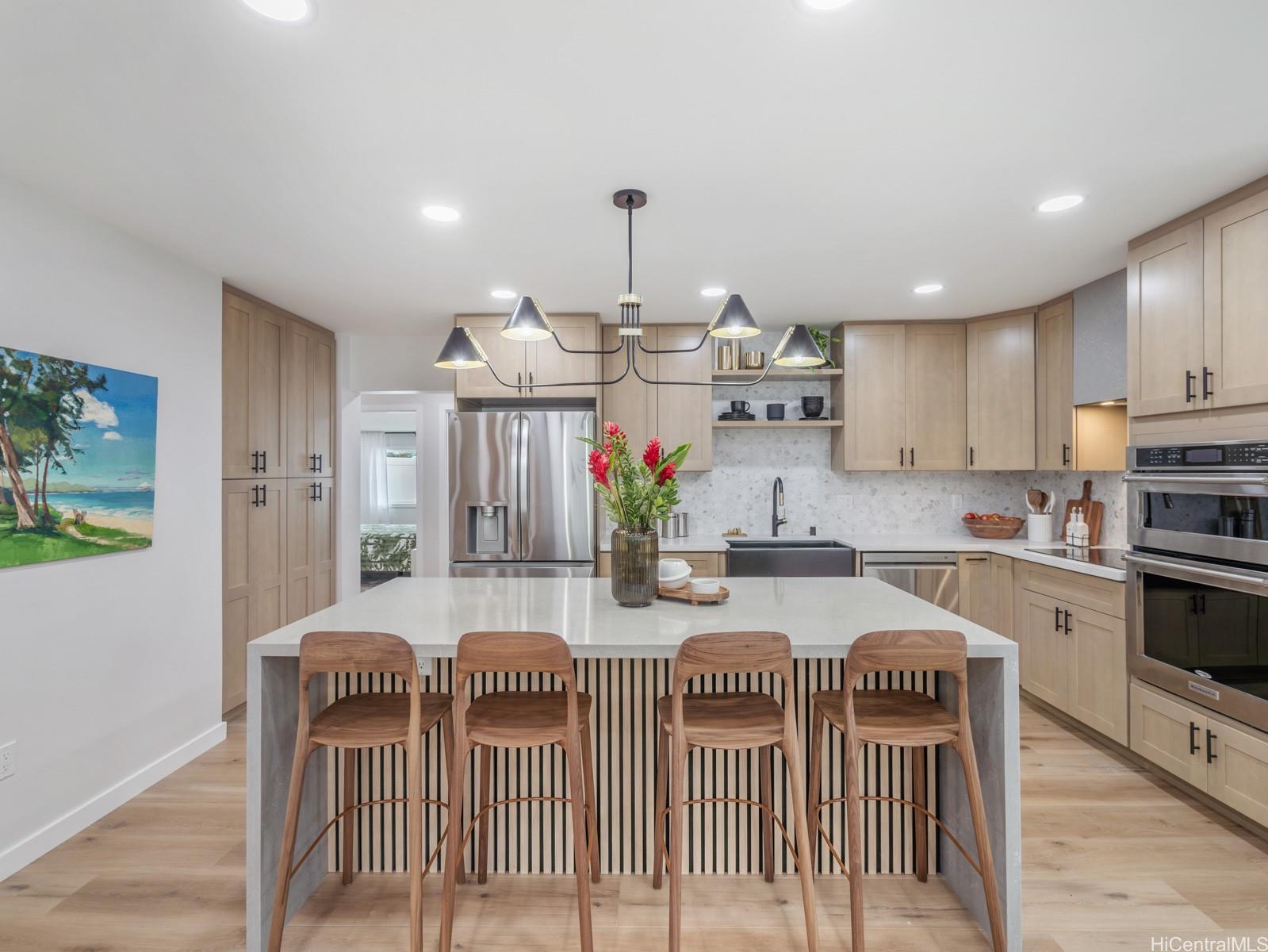 a kitchen with kitchen island granite countertop a sink a stove a dining table and chairs