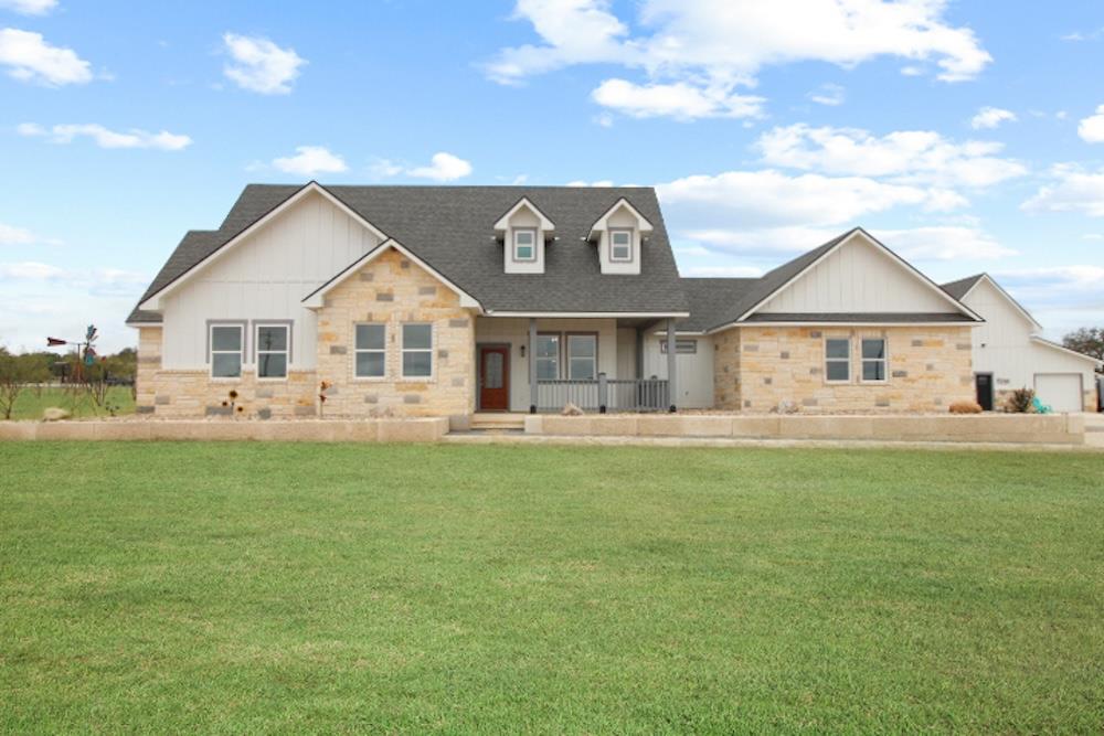 a front view of a house with a garden and yard