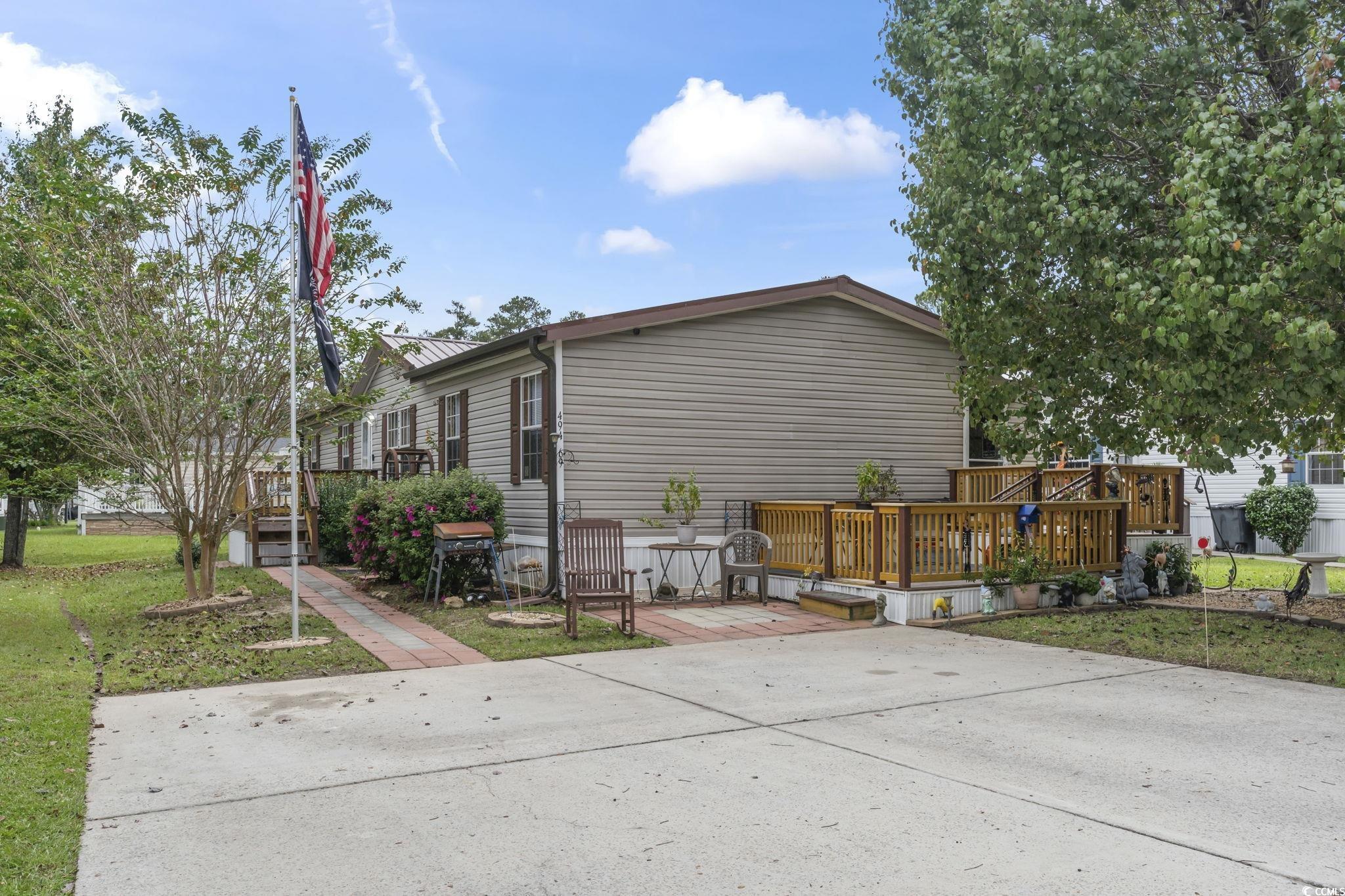 View of property exterior with a deck and a yard