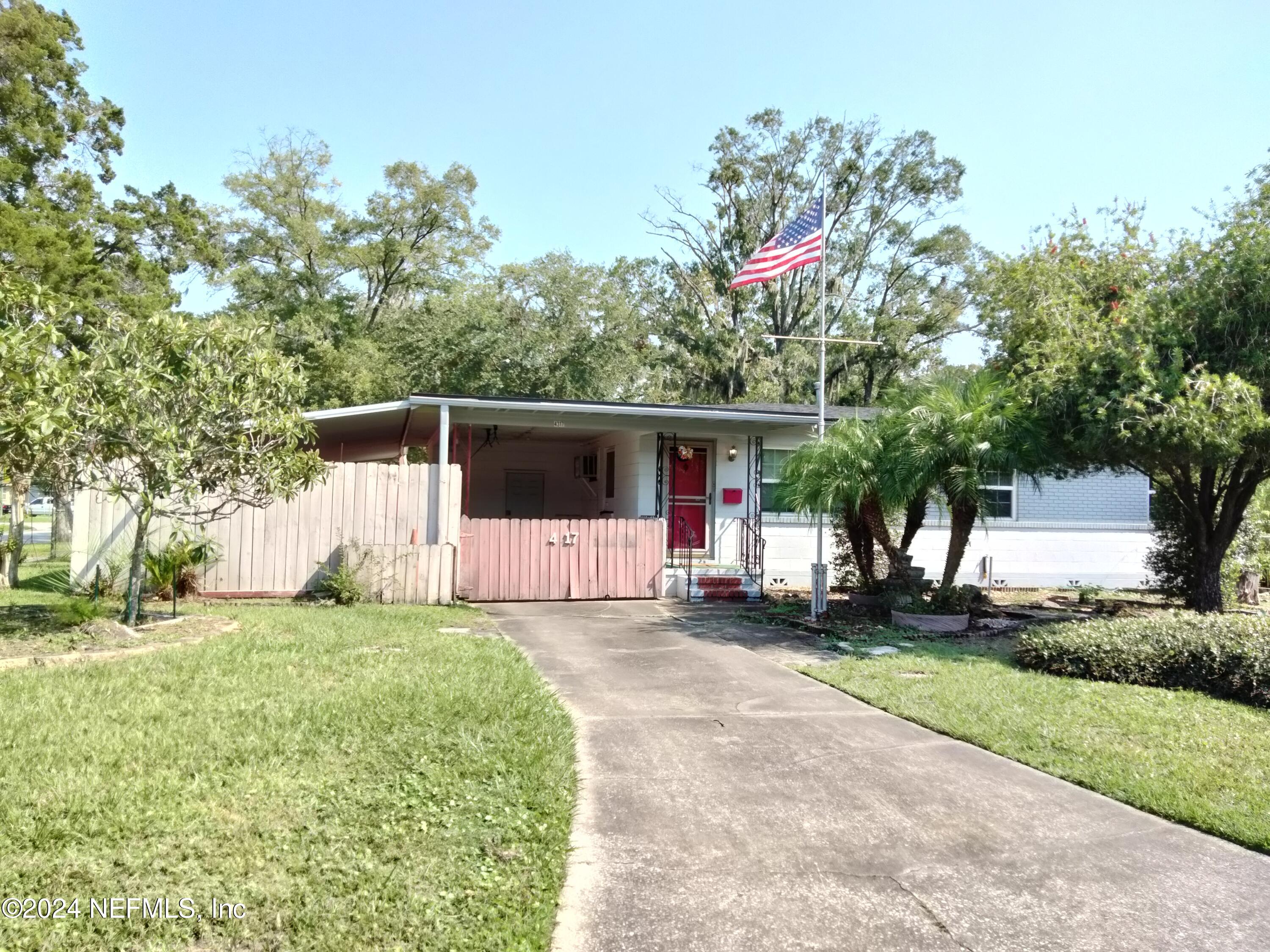 a front view of a house with a yard and trees