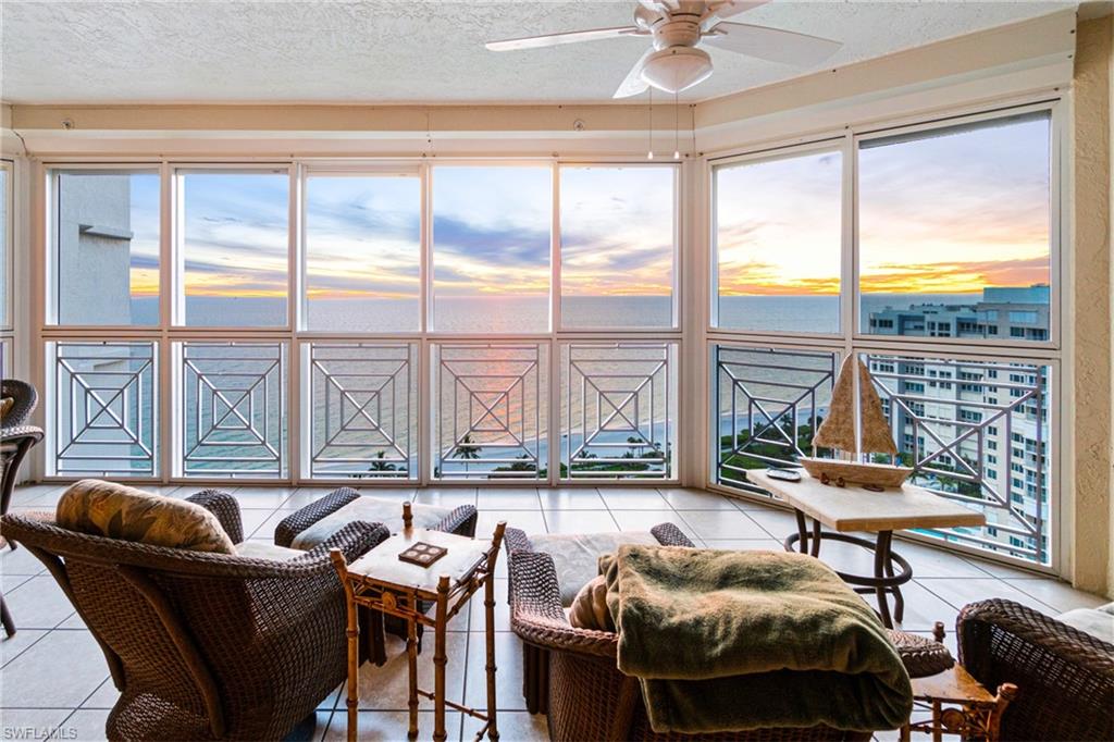 a living room with furniture and floor to ceiling windows