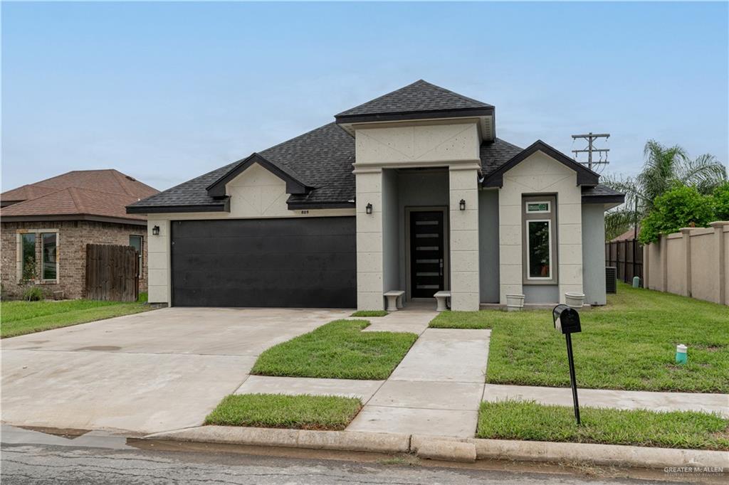 View of front of house with a garage and a front yard