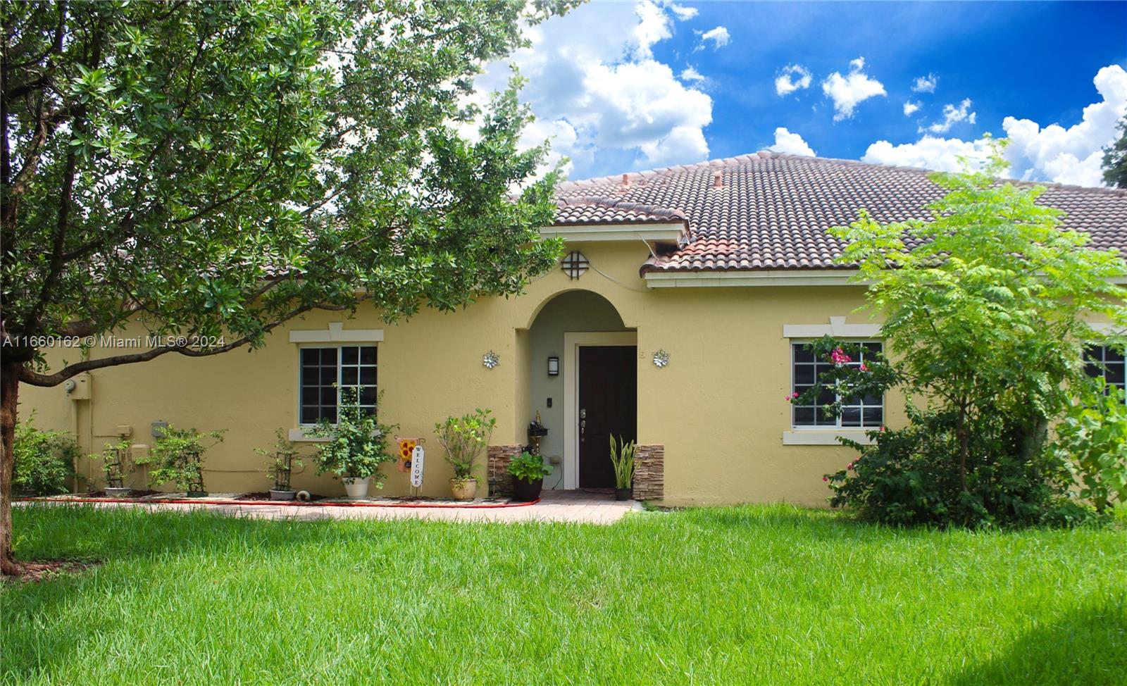 a front view of a house with a garden