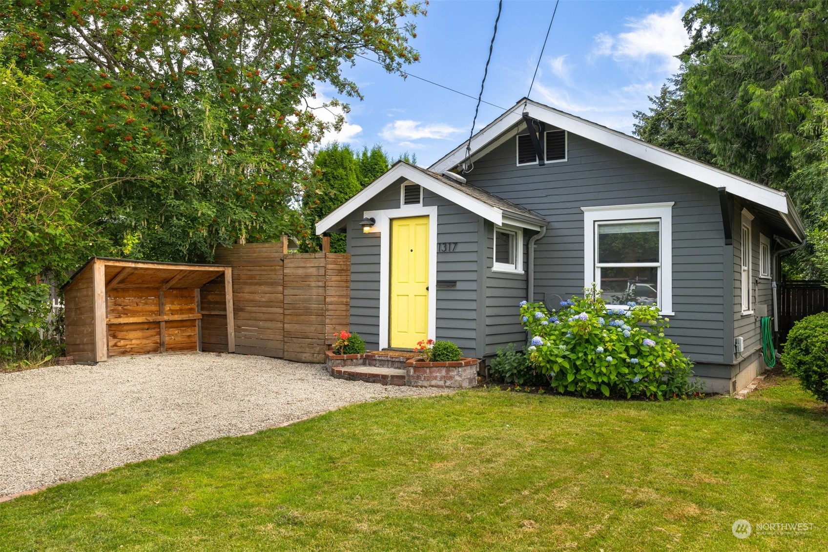 a front view of house with yard and trees in the background