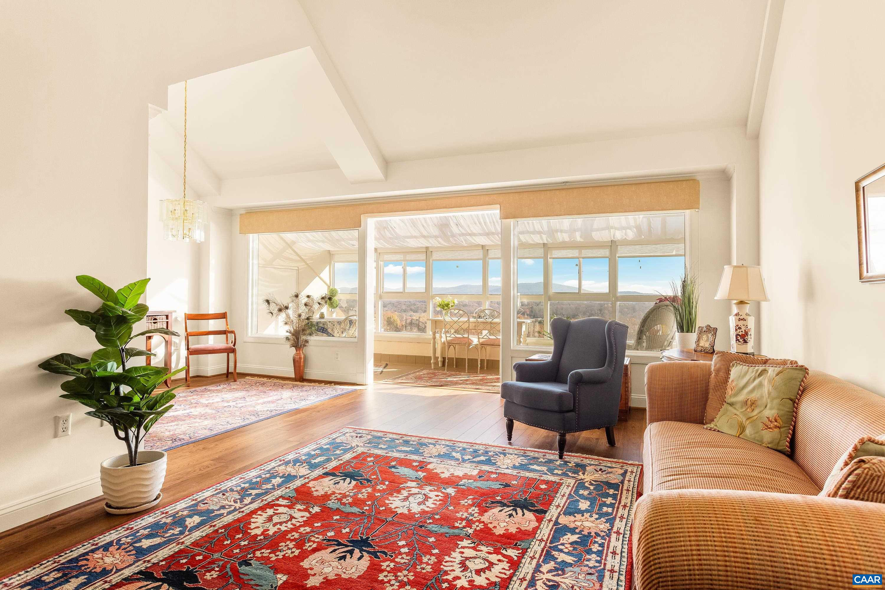 a living room with furniture potted plant and a large window