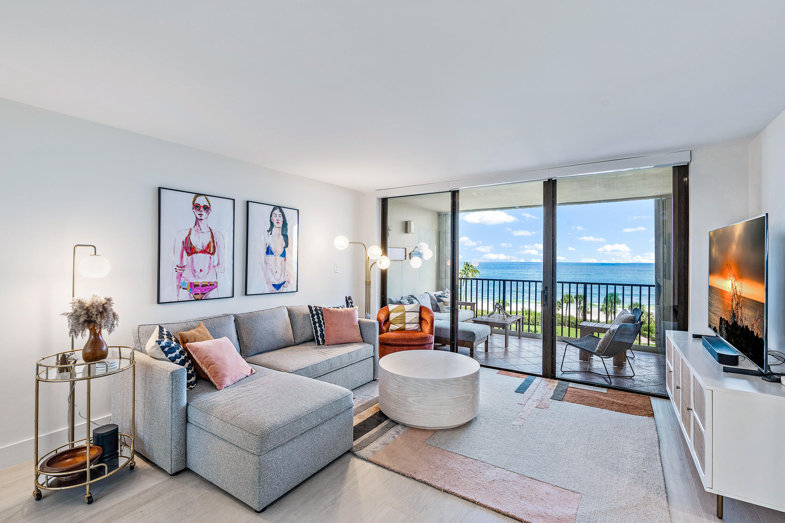 a living room with furniture a flat screen tv and a large window