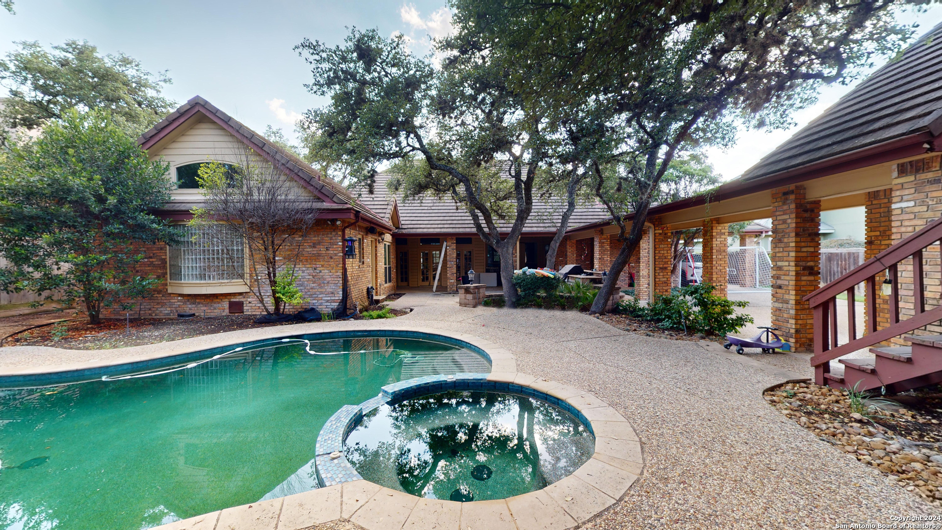 a front view of a house with a garden and swimming pool