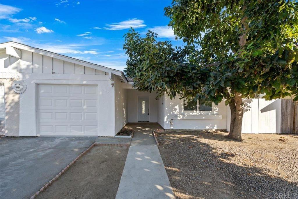 a view of a house with a tree in front of it