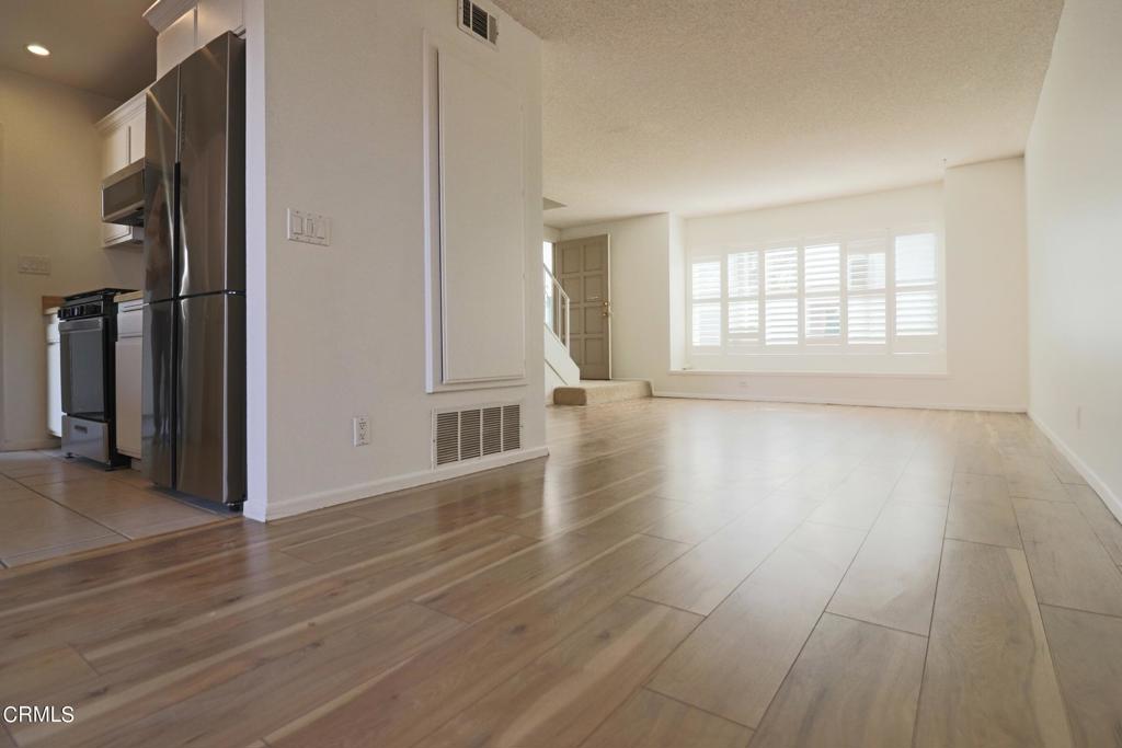 an empty room with wooden floor and a fireplace