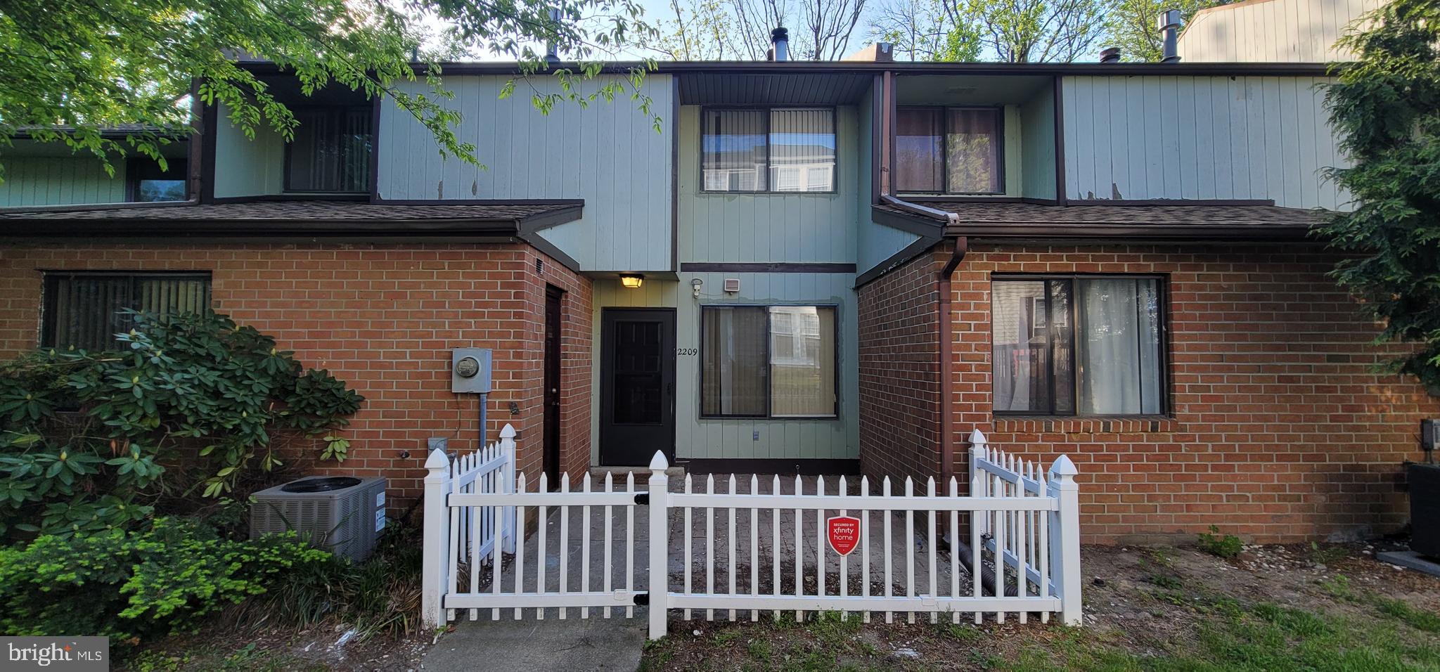 a view of a house with a small yard and wooden fence