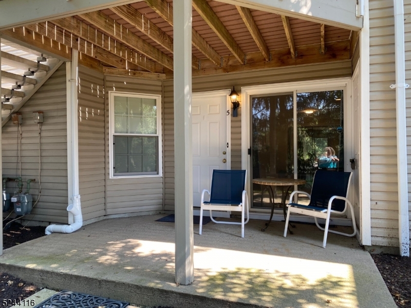 a view of a two chairs in the patio and a room