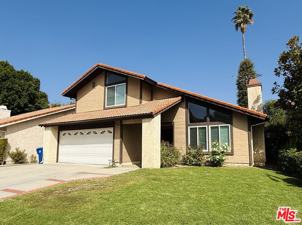 a front view of a house with a garden and yard