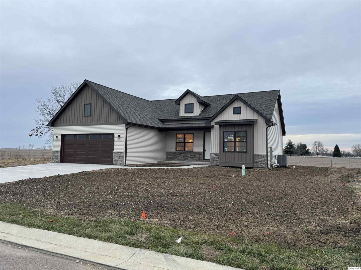 a front view of a house with a yard and garage