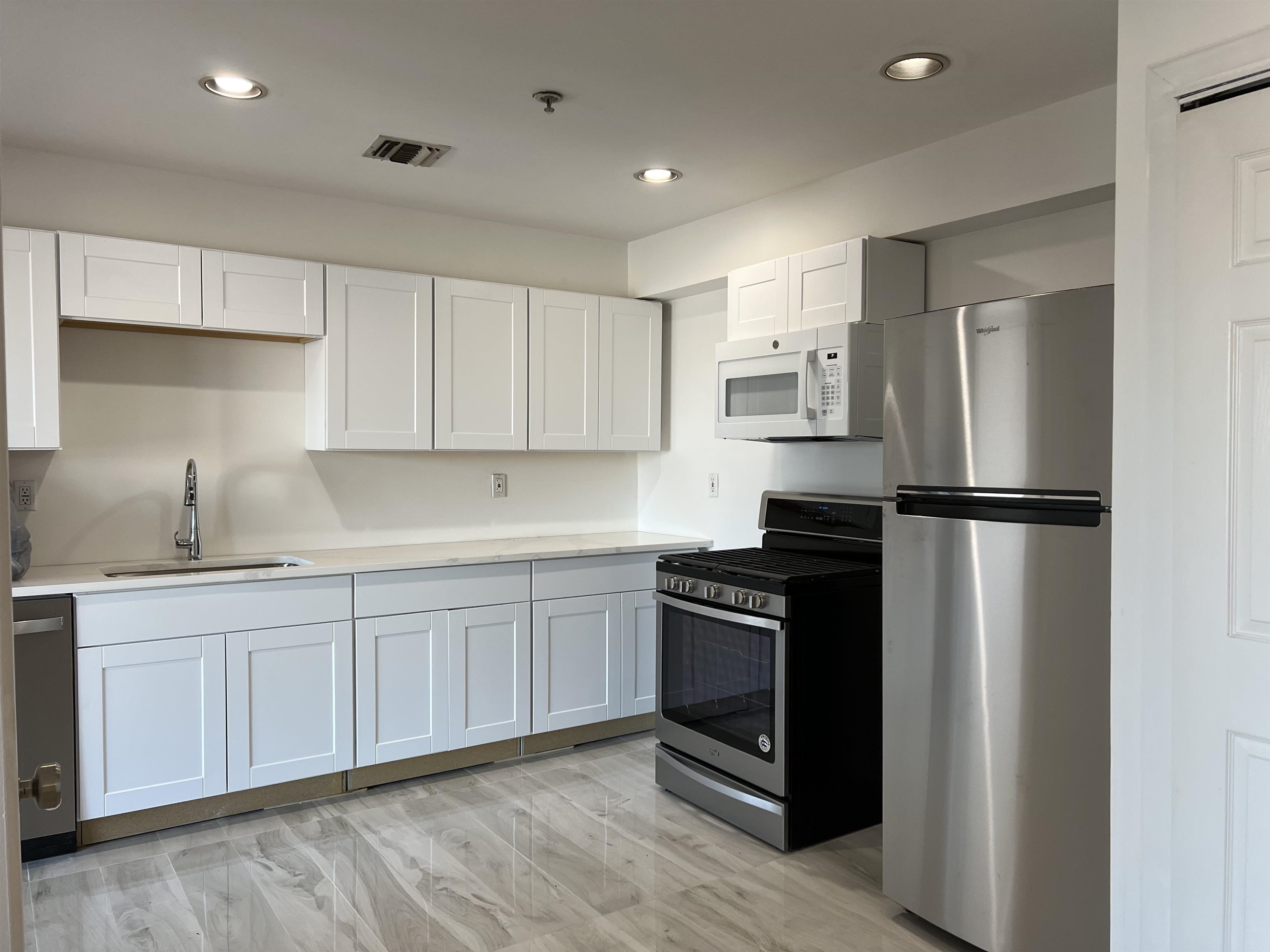 a kitchen with a refrigerator sink and cabinets