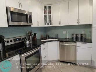 a kitchen with stainless steel appliances granite countertop a stove a microwave and cabinets