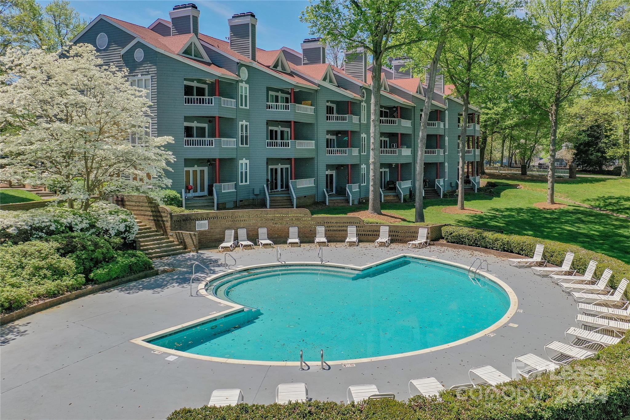 a view of a swimming pool with a patio and a garden