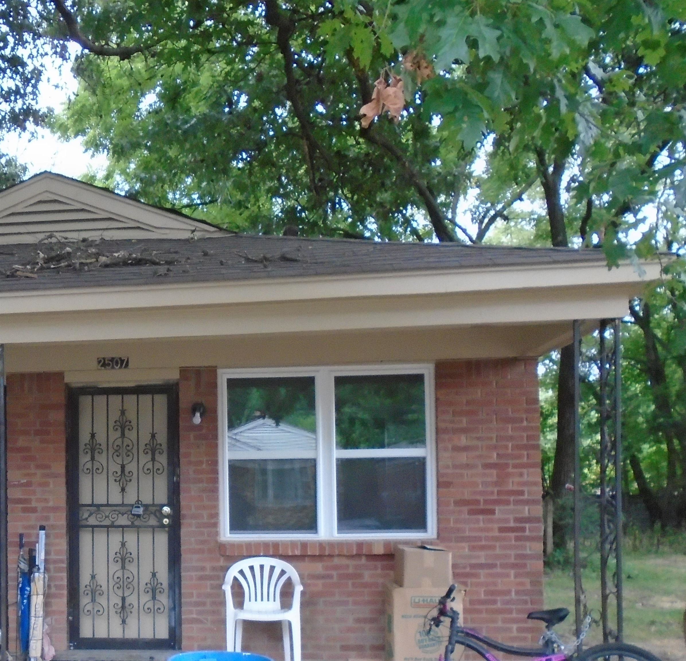 a front view of a house with a tree