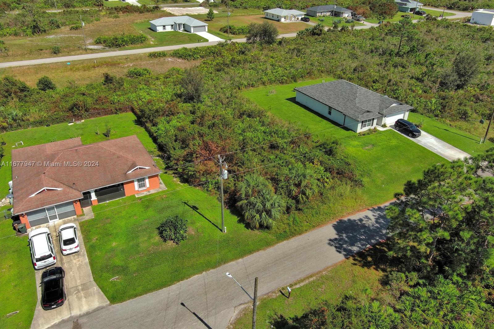 an aerial view of residential houses with outdoor space and street view