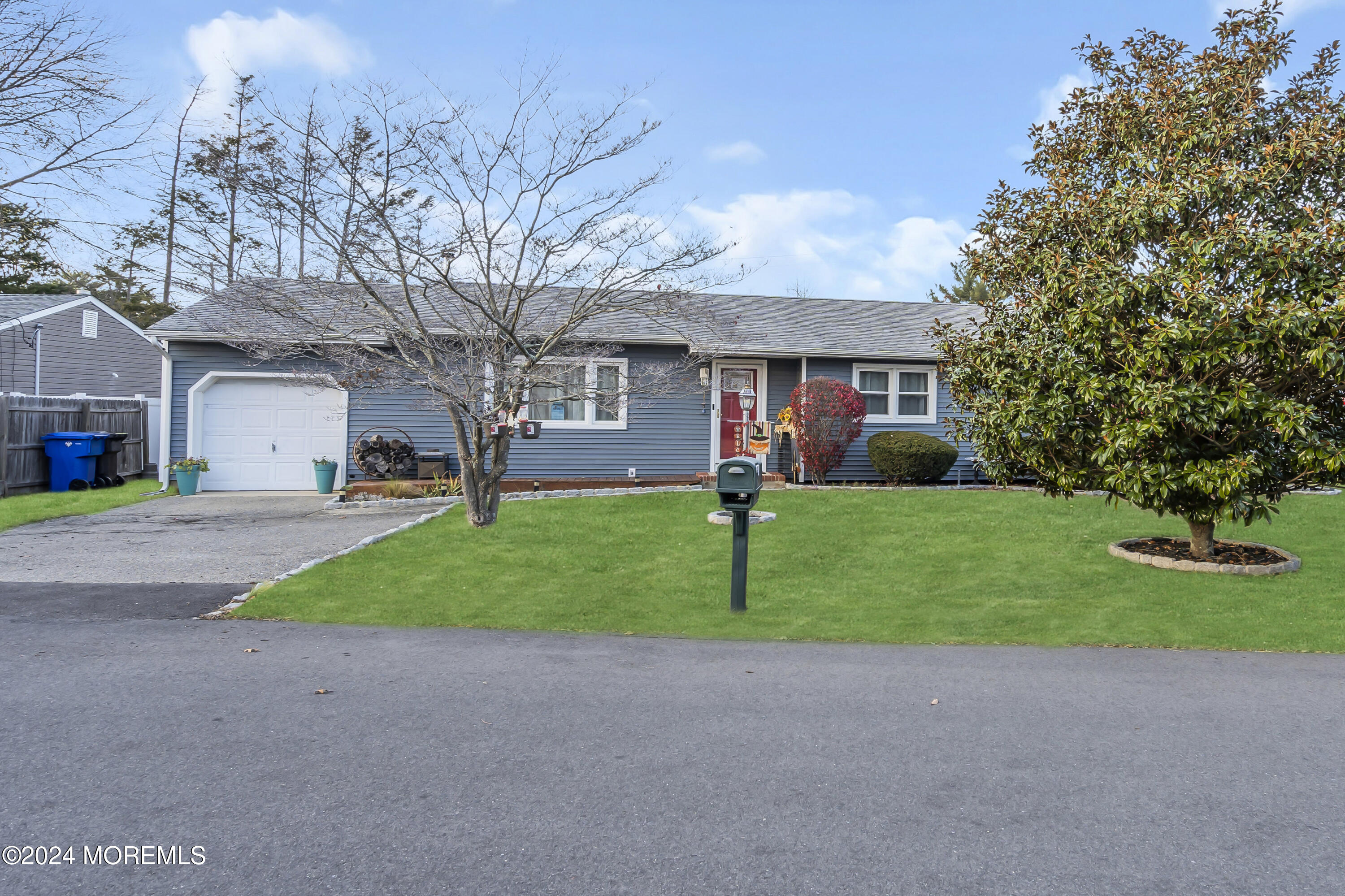 a view of a house with a yard and large tree