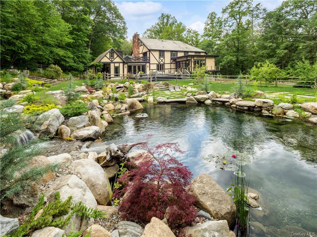 a view of a house with a yard and a pond