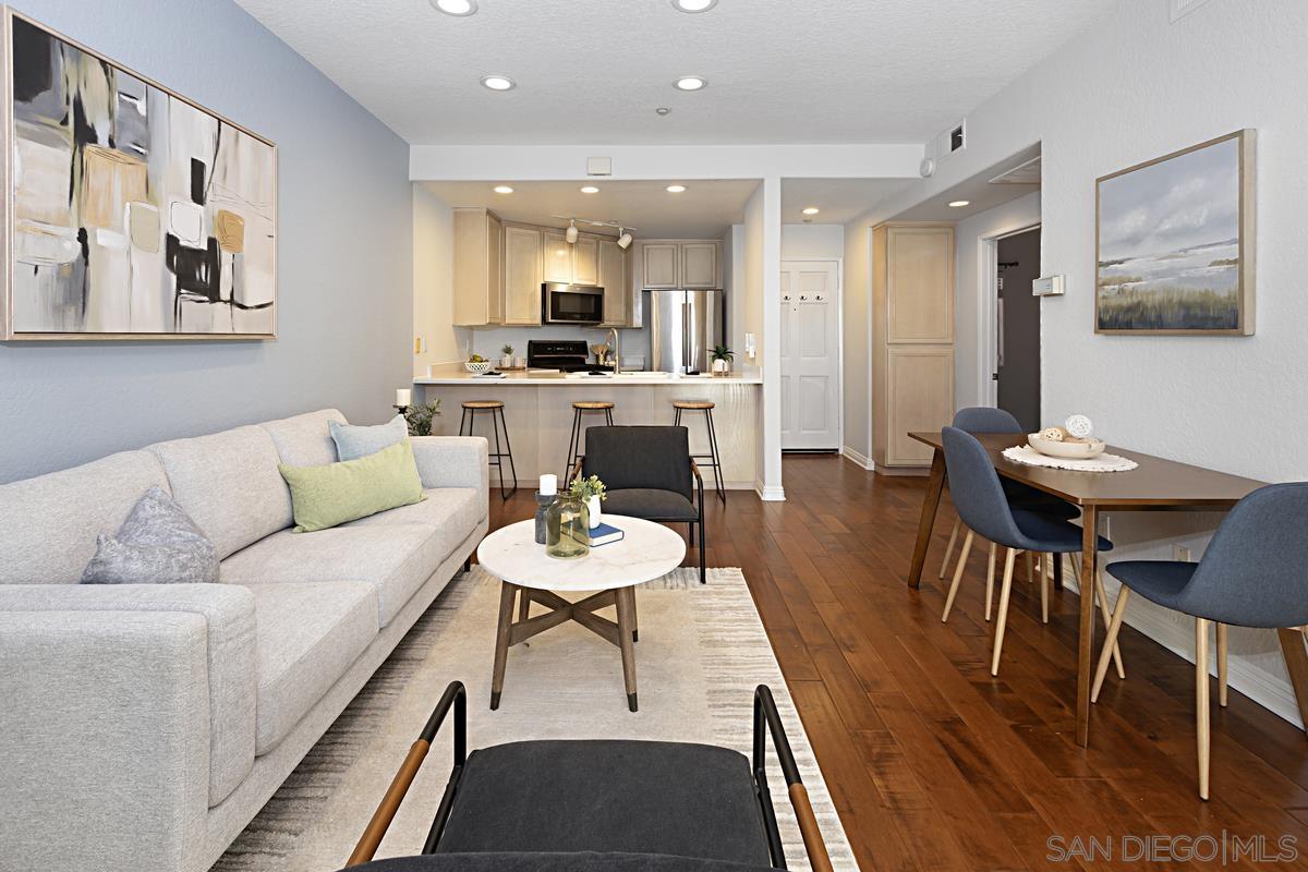 a living room with furniture and a dining table with kitchen view