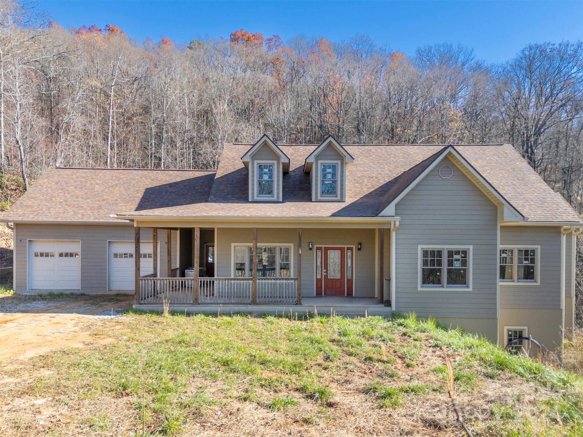 a front view of a house with a yard and mountain view