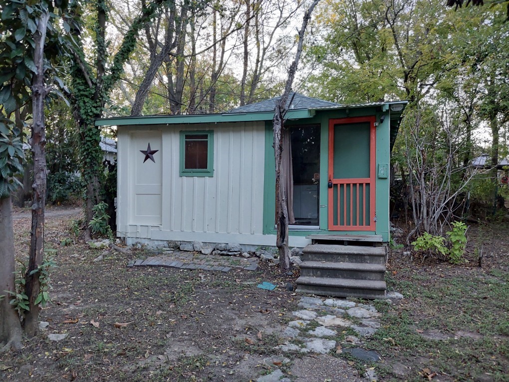 a view of a house with a yard and wooden fence