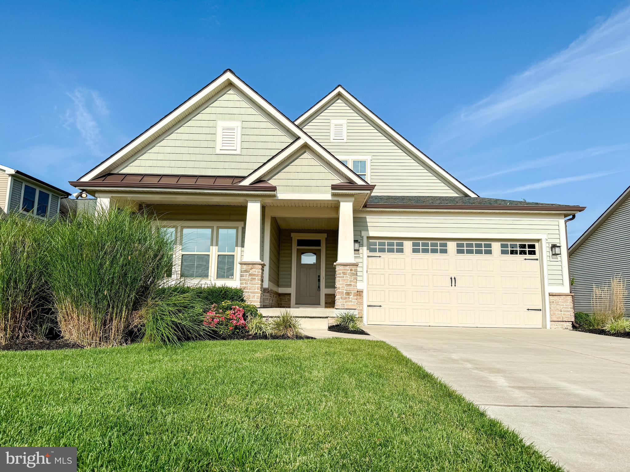 a front view of a house with a garden and plants