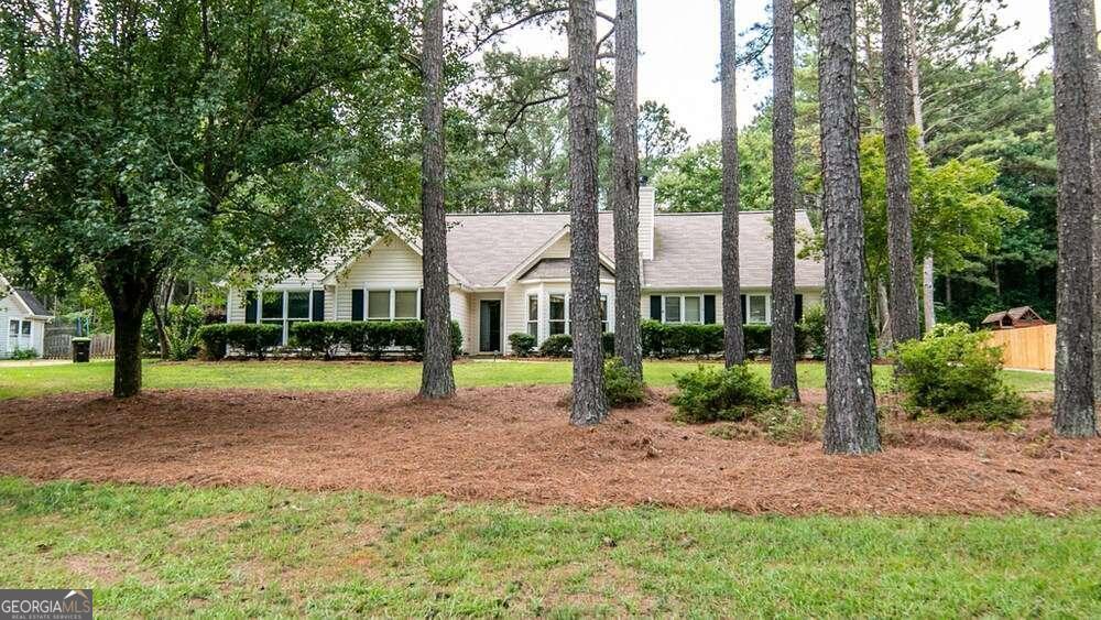 a view of a house with backyard and a tree