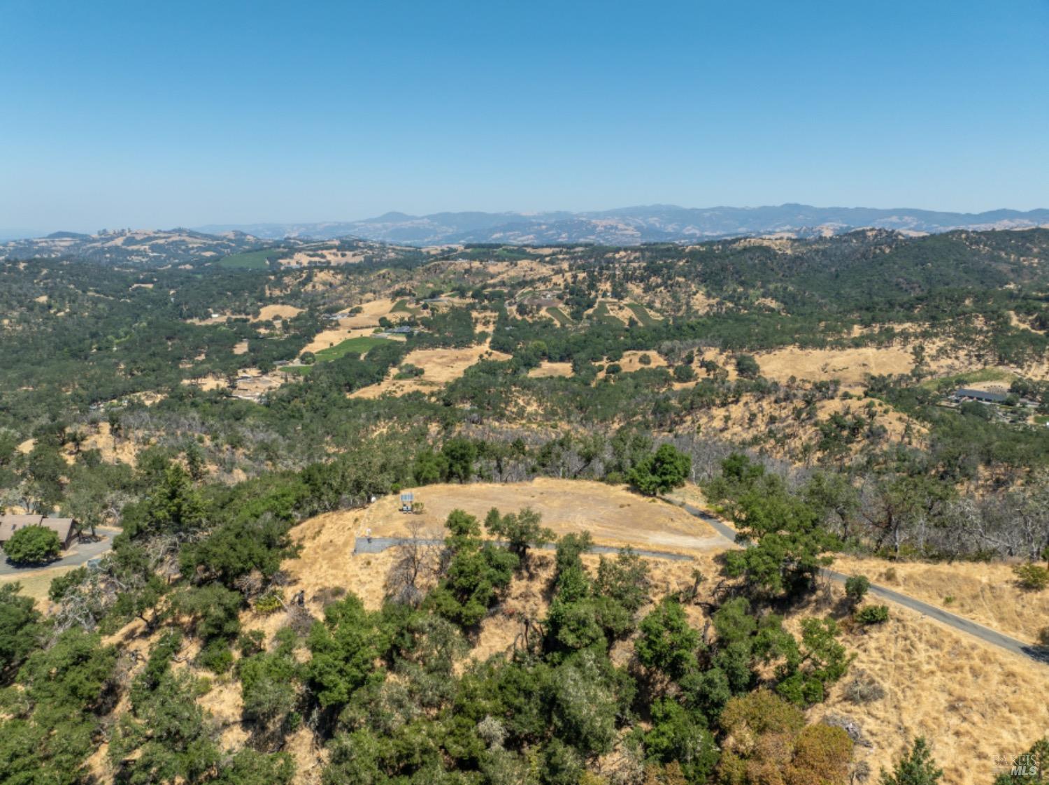 an aerial view of house with yard and mountain view in back