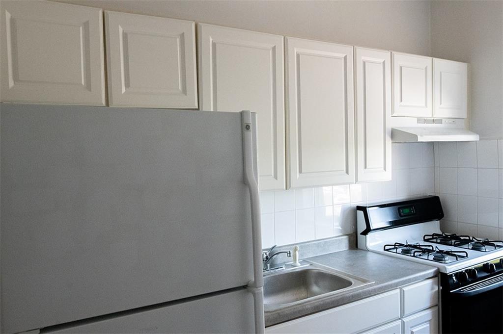 a kitchen with granite countertop white cabinets and a stove with a sink