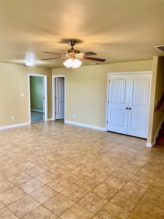 an empty room with windows and fan