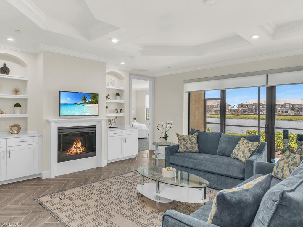 a living room with furniture a fireplace and a floor to ceiling window