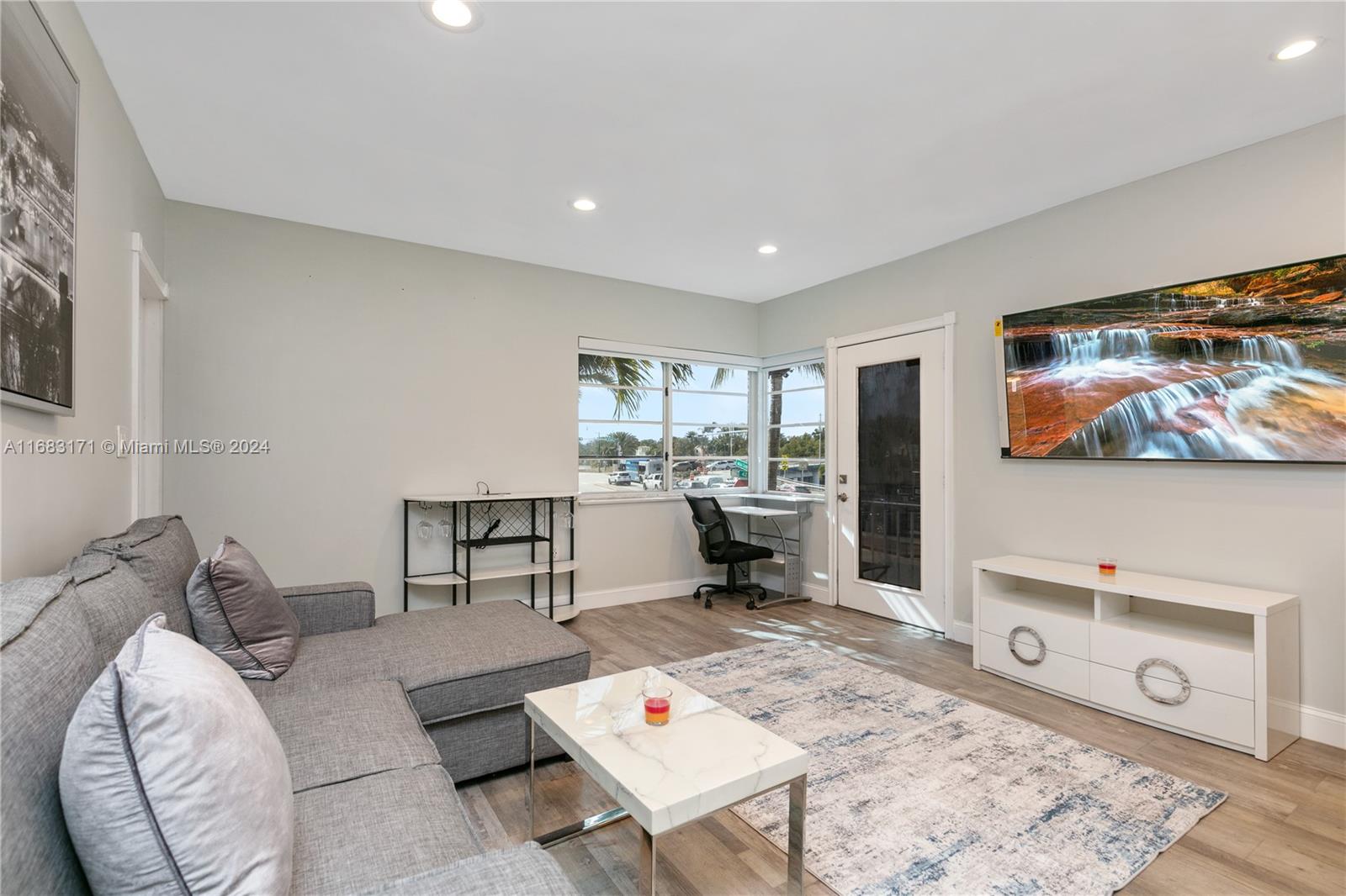 a living room with furniture and wooden floor