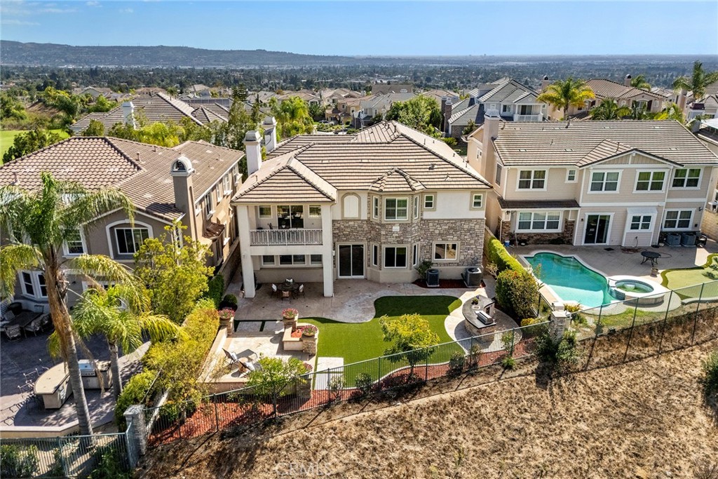 an aerial view of a house with swimming pool lawn chairs and a yard