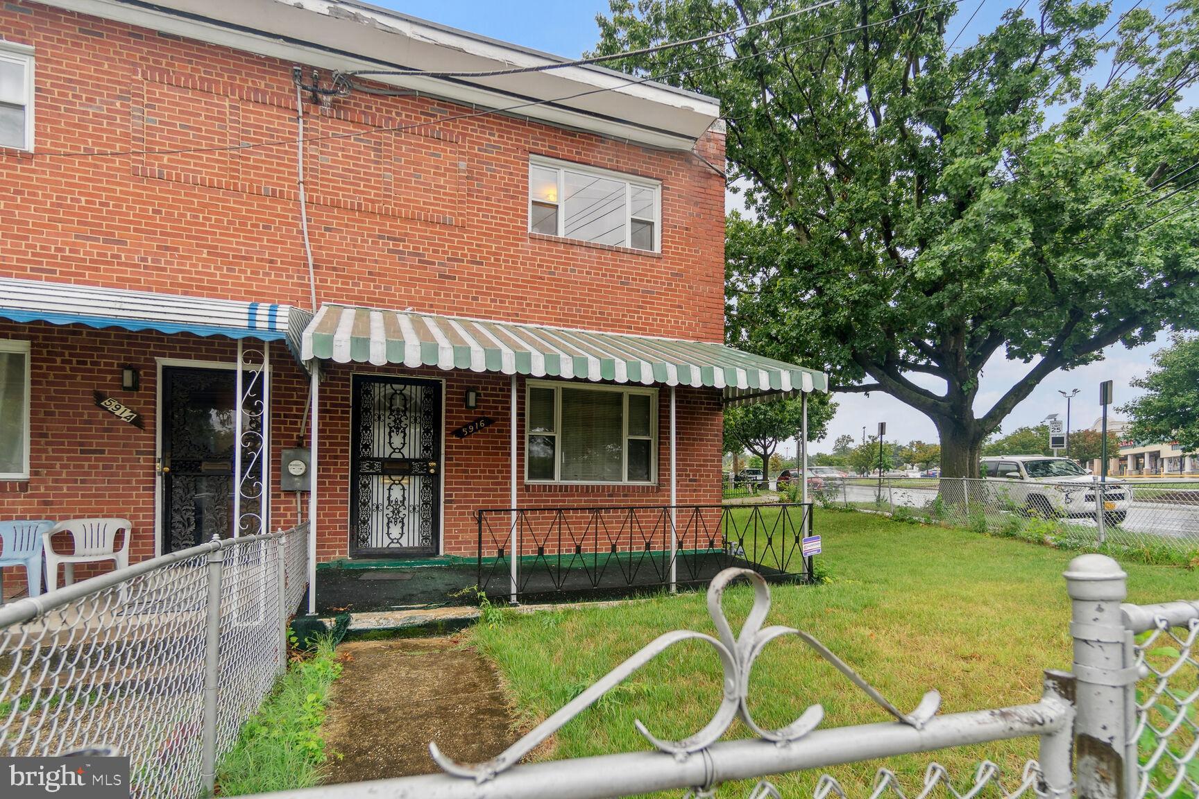 a view of a house with backyard and a tree