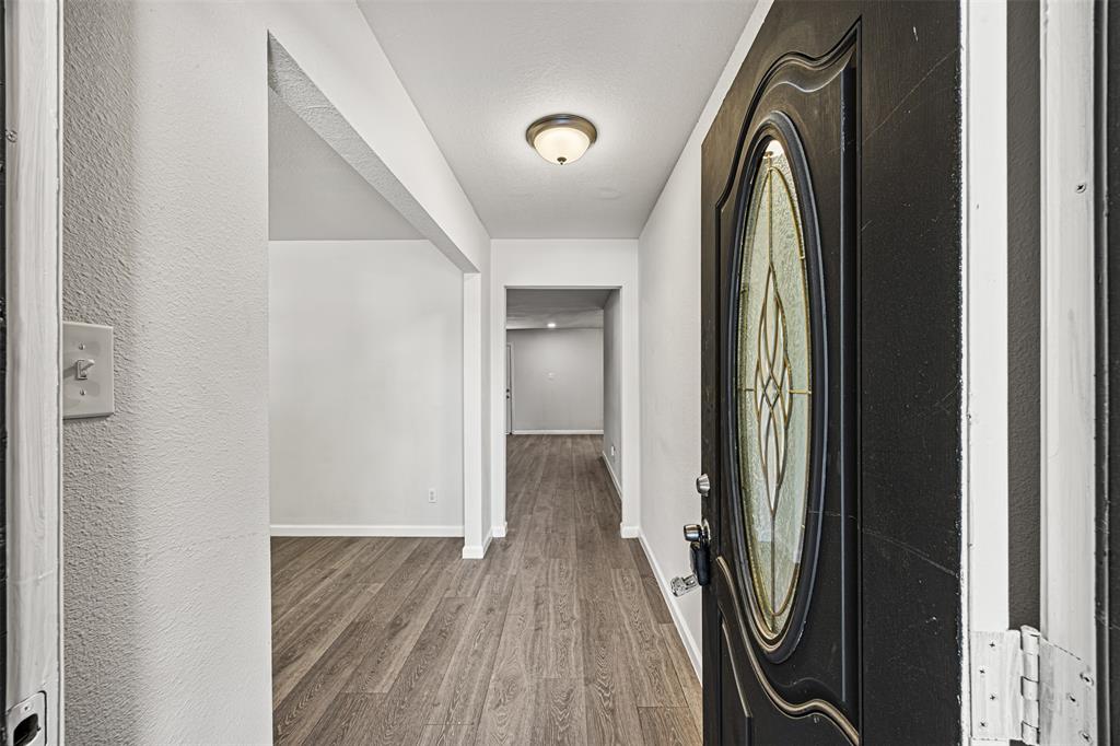 a view of a hallway with wooden floor and staircase