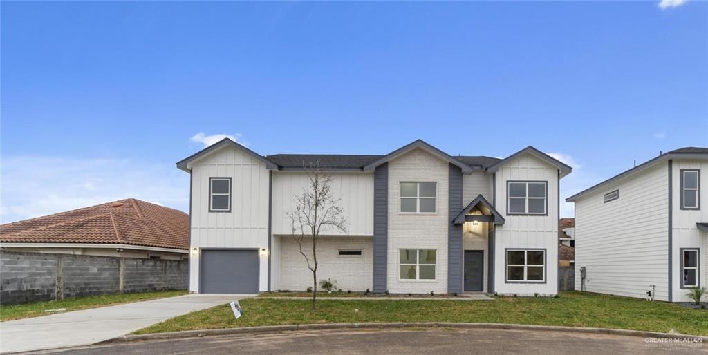 View of front of property with a garage and a front lawn