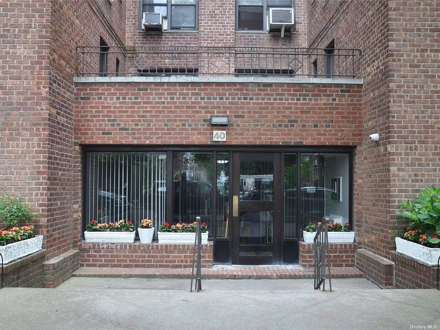 front view of a brick building with a bench in front of building