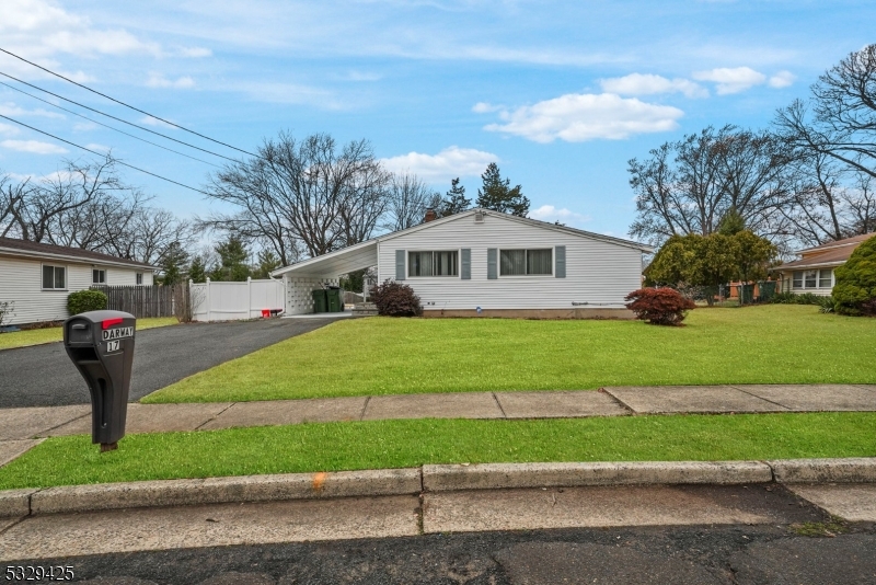 a front view of a house with a yard and green space