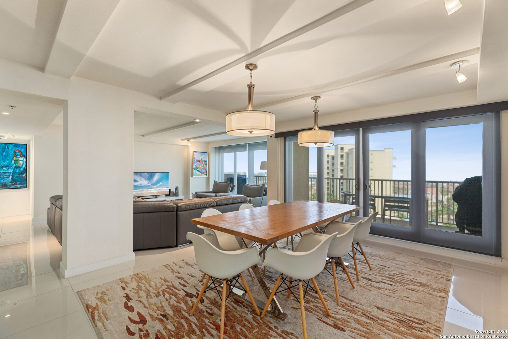 a dining room with wooden floor a chandelier a wooden table and chairs