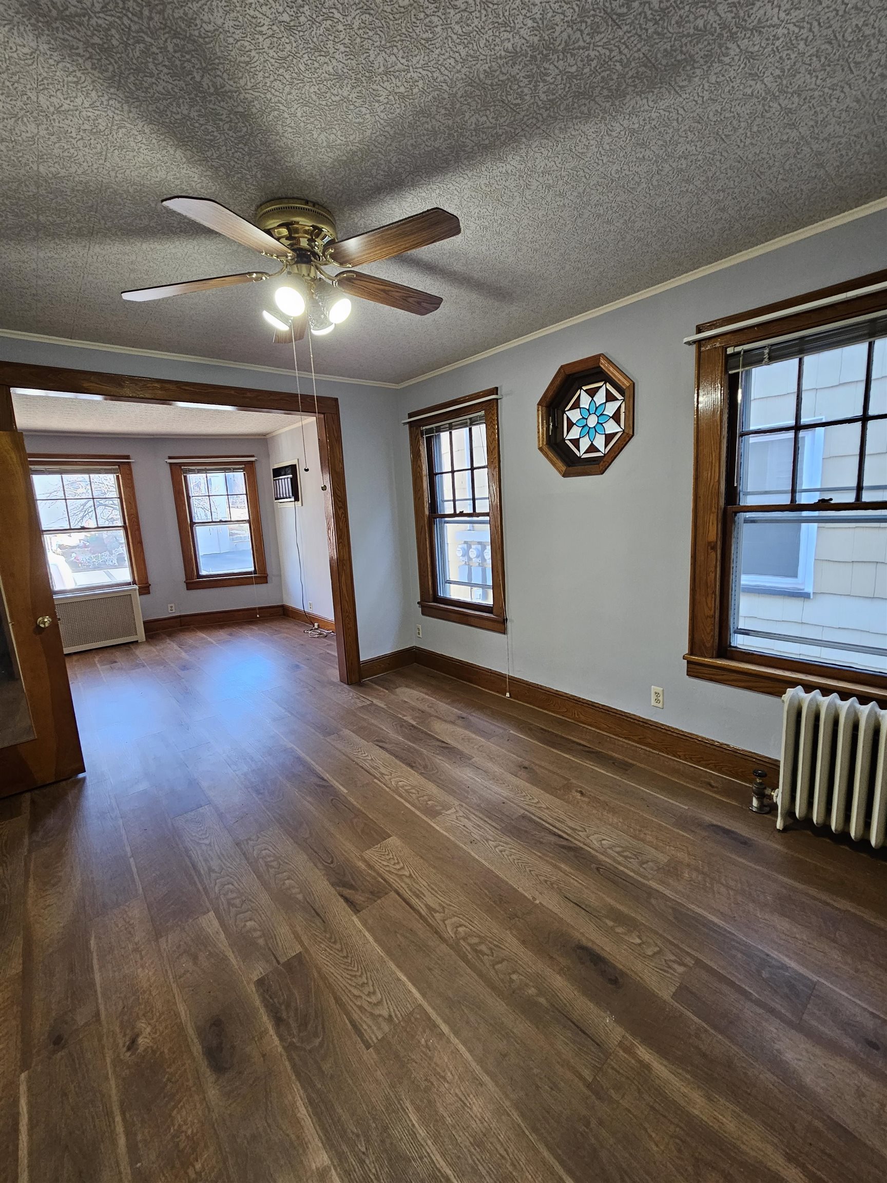 an empty room with wooden floor and windows