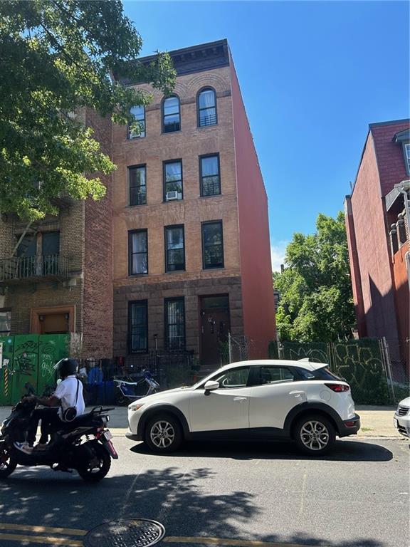 a view of a car parked in front of a brick house