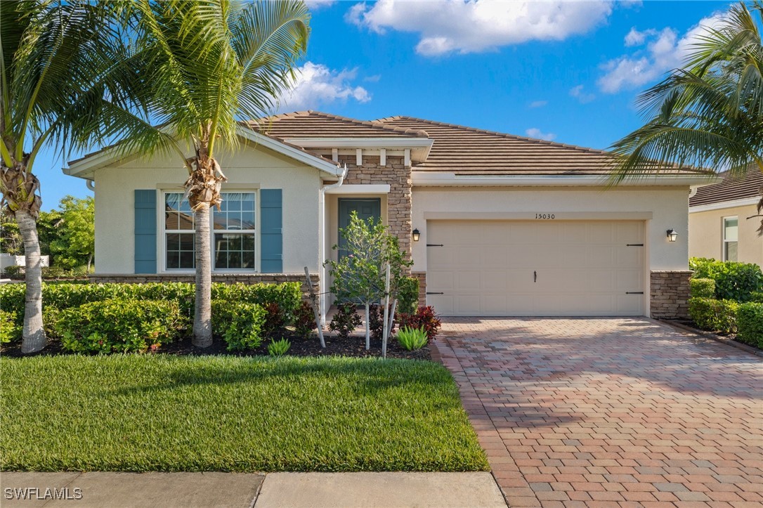 a front view of a house with a yard and potted plants