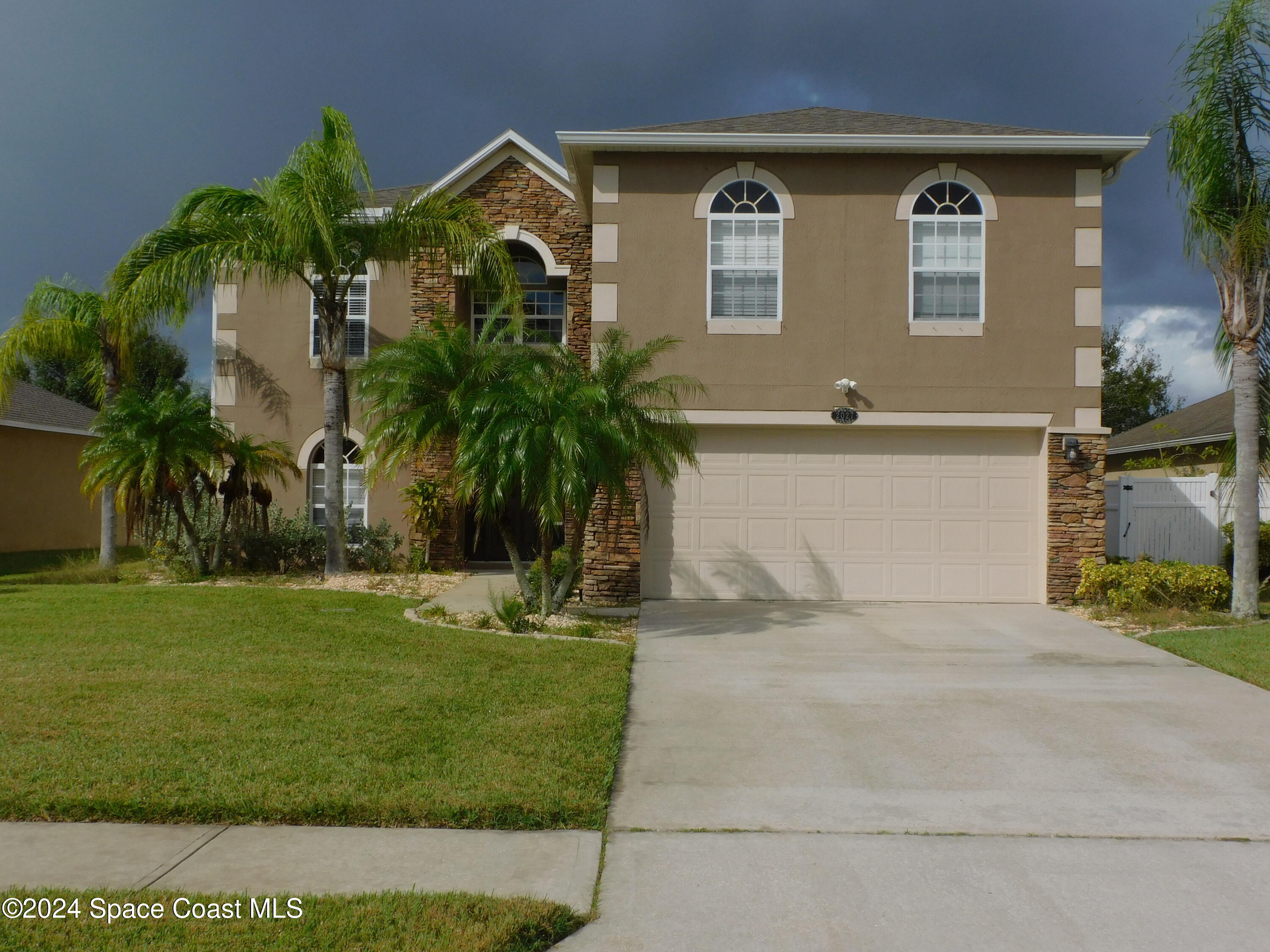 a front view of a house with a yard and garage